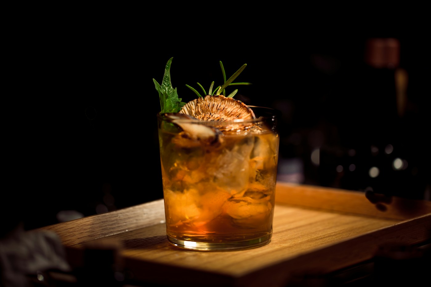 An amber cocktail with citrus and herbs