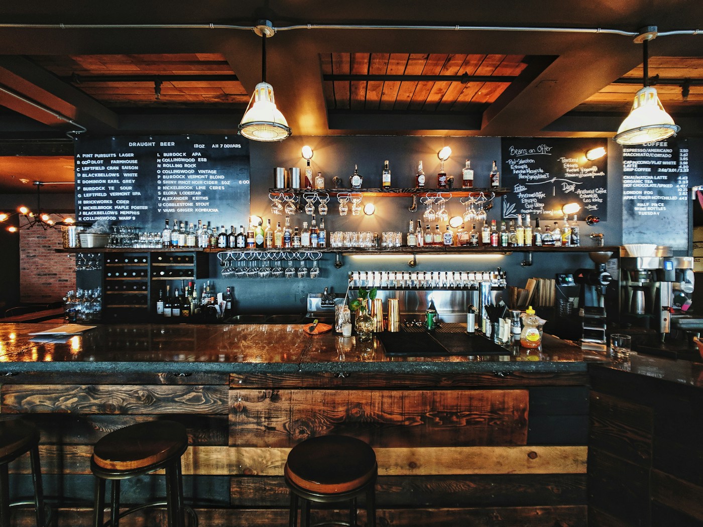 A warmly lit bar with bottles and glassware